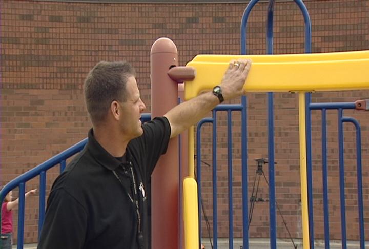 Salt Lake Valley Health Department inspector Greg Langfeld examines the playground at Calvin Smith Elementary School