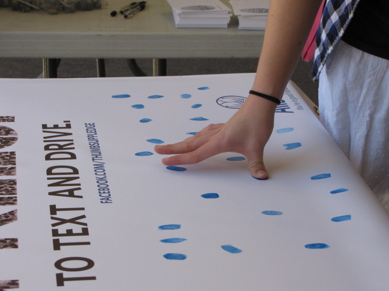 Students at Skyline High used their texting thumbs and ink to make a pledge not to text and drive.