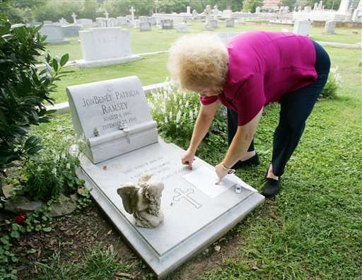 Lib Waters, a long-time resident of Marietta, Ga., and friend of the Ramsey family, tapes a letter to the gravestone of JonBenet Patricia Ramsey, Wednesday, Aug. 16, 2006, at the St. James Episcopal Church Cemetery in Marietta, Ga. The letter said "Dearest Patsy. Justice has come for you & John. Rest in Peace! Your friend Lib Waters." A man arrested in Thailand is being held in connection with the slaying of JonBenet Ramsey, U.S. officials said Wednesday, Aug. 16, 2006. Federal officials familiar with the case, who spoke on condition of anonymity, said the man was already being held in Bangkok on unrelated sex charges. The girl was found beaten and strangled in the basement of the family's home in Boulder, Colo., on Dec. 26, 1996. (AP Photo/Ric Feld)