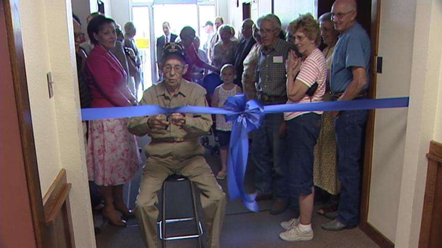 Roger Johnson cut the ribbon Friday to a new exhibit of memorabilia he collected as a pilot during World War II.