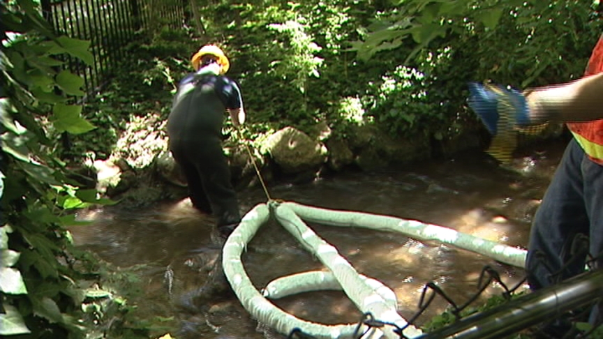 Cleanup crews began repositioning booms late Friday to capture oil when the creek suddenly runs higher Saturday morning