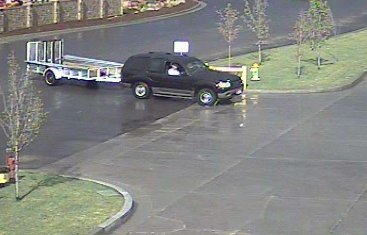 Surveillance photos show the men in an SUV loaded $60,000 worth of equipment on a trailer before driving away.