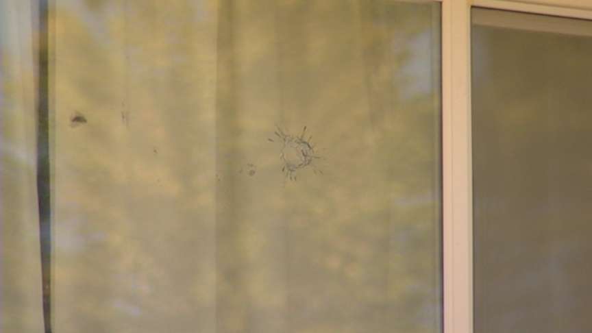 A bullet went through the bedroom window and struck a woman in the shoulder