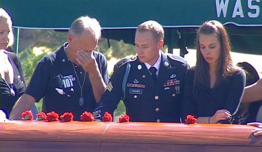 Aaron Kramer's father Rick Kramer, twin brother Brandon Kramer and wife Jackie Kramer stand over his casket.