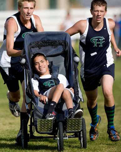 Mack Bawden (right) and Logan Anderson (left) push Cameron Judd (center) as they run cross country. (Mike Terry/Deseret News)