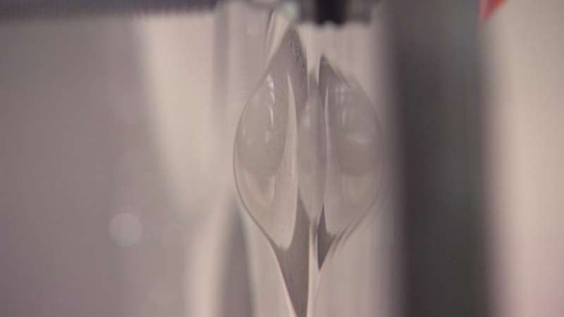 As the bullet hits the glass, polycarbonate keeps it from going through.
