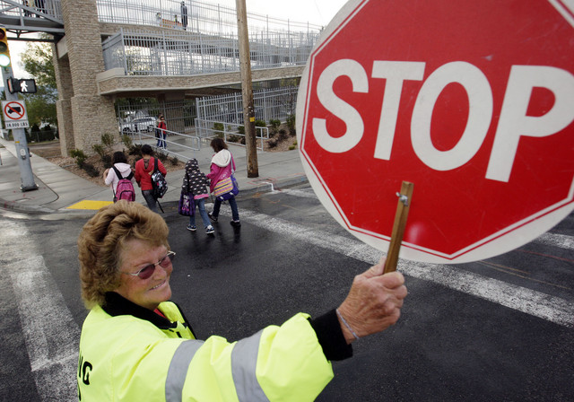Calvin Smith Elementary school crossing guard Maxine Christensen helps children walk to school in Taylorsville on Oct. 6, 2010. As the start of school approaches, crossing guards are in demand around the state.