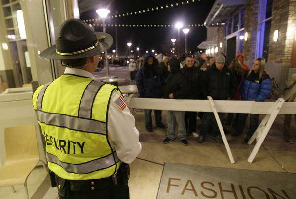Security hold anxious customers for the 9pm opening at the Fashion Place Mall in Salt Lake City, Utah, Thursday, Nov. 25, 2010. Fashion Place Mall was kicking off holiday shopping season with \"Jump on the Jingle\" giving shoppers the earliest opening of any store in Utah. (Jeffrey D. Allred, Deseret News)