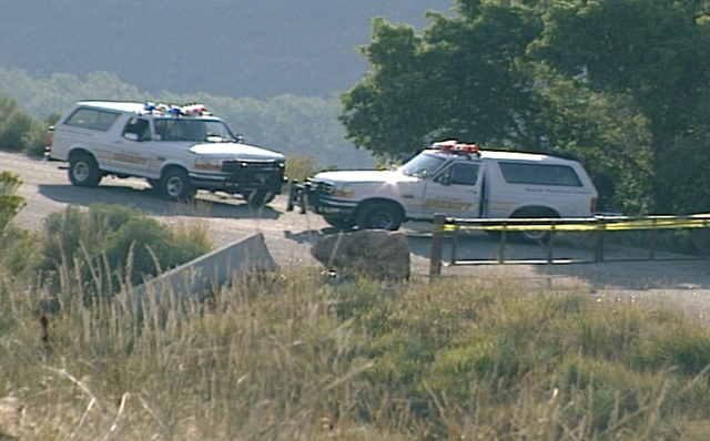 This 1996 photo shows law enforcement agencies investigating the scene near Little Dell Reservoir where Yvette Rodier Evans and her friend Zach Snarr were shot. Snarr did not survive.