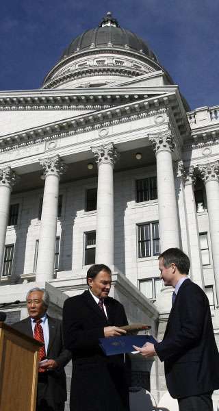Gov. Gary Herbert, at center of photo, is presented a .22-caliber Browning pistol by Chris Browning, at right, during a celebration of John M. Browning Day.(Ravell Call, Deseret News)