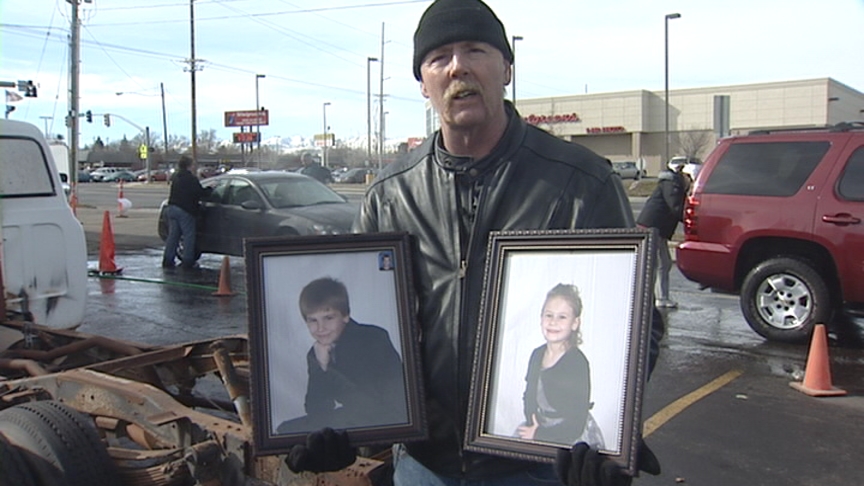 Gerald Karrick, future stepfather to Stephen and Tasha Pio, holds pictures of the children at a car wash held to raise money for their recovery Saturday