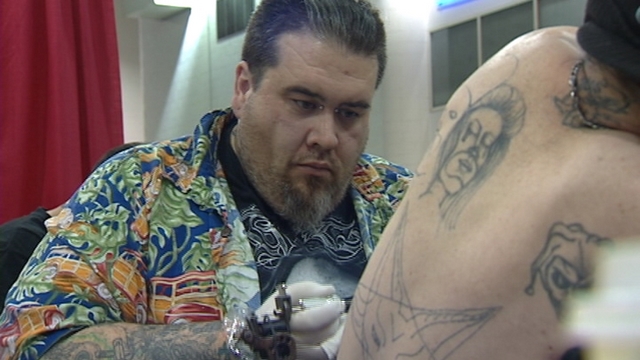 David Garlitz, tattoo artist of 13 years, giving Tony Michelli, of Corinne, his 66th tattoo.