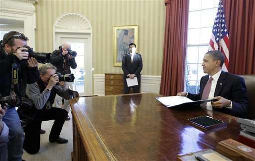 President Barack Obama finishes signing the two-week funding bill averting a government shutdown in the Oval Office at the White House in Washington, Wednesday, March 2, 2011. (AP Photo/Charles Dharapak)