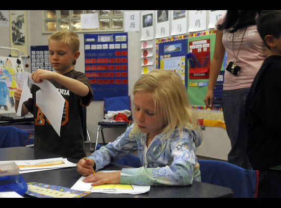 First-graders Tanner Fritzsche, left, and Kaylin Sabey color and cut out figures after learning new vocabulary words in Mandarin at Foothills Elementary School in Riverton Monday, April 11, 2011. The teacher and students communicate only in Mandarin during class.