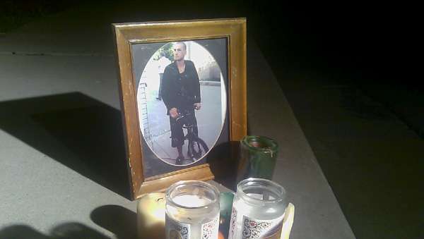 A neighbor provides a picture of Sean Krummi at a memorial outside a West Valley home.