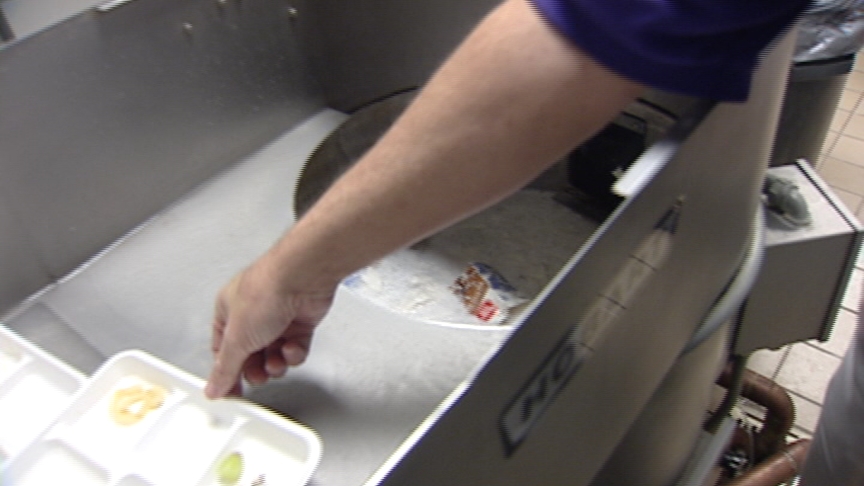 The "Chomper" and "melter" work to turn the lunch trays into recyclable, plastic cubes.