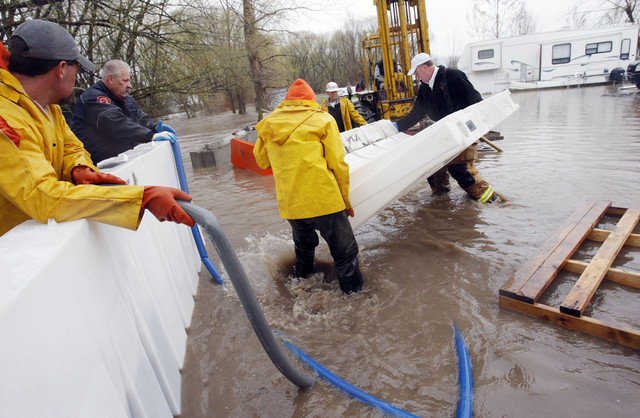 Workers install plastic barriers to help divert water from Riverside RV Park Monday, April 18, 2011, near the Blacksmith Fork River south of Logan. (Scott G. Winterton, Deseret News)