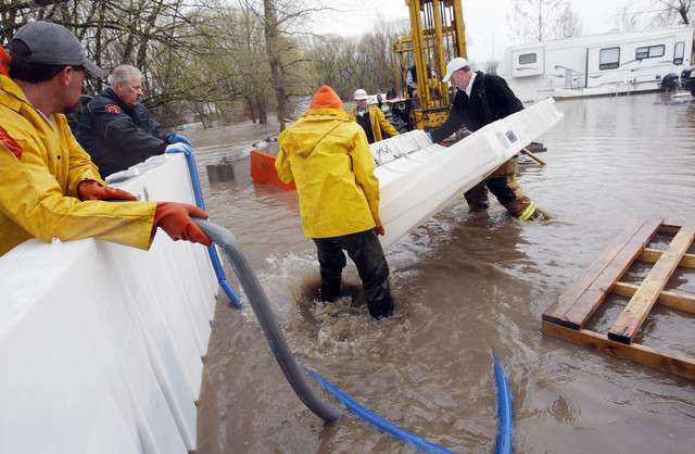 Workers install plastic barriers to help divert water from Riverside RV Park Monday, April 18, 2011, near the Blacksmith Fork River south of Logan. (Scott G. Winterton, Deseret News)
