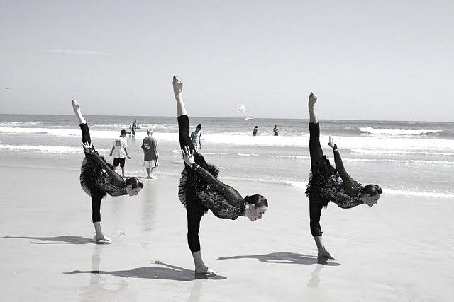 Three of the Cougarettes perform an Arabesque Penchee on the beach after the competition.