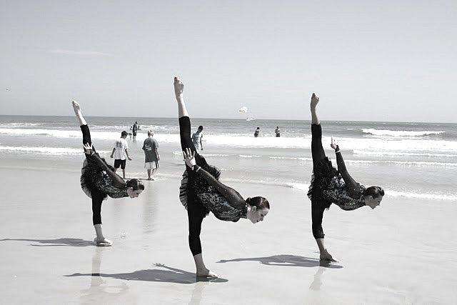 Three of the Cougarettes perform an Arabesque Penchee on the beach after the competition.