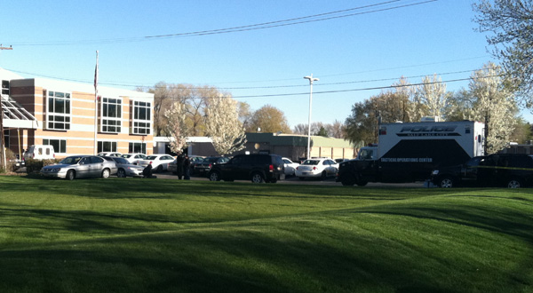 A family member of the man involved in a police standoff was tackled by officers. He's sitting on the curb in handcuffs.