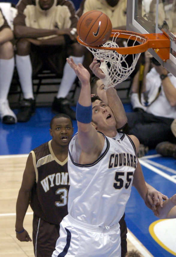 BYU's Rafael Araujo (55) gets bumped by Wyoming's Alex Dunn after tipping in a rebound as BYU faces Wyoming in the opening round of the Mountain West Conference Championship in Denver Thursday, March 11, 2004. Photo by Jason Olson