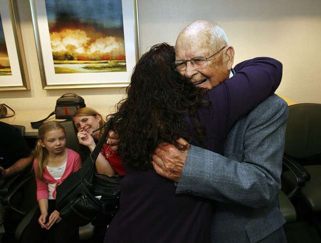 Herbert Russell, right, 87, is hugged by his granddaughter, Debra Cox, as he is honored for 56 years of volunteer hospital service.