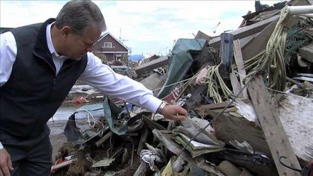 KSL 5 News anchor Bruce Lindsay sifts through a pile of rubble, finding notebooks, hangers and shoes.