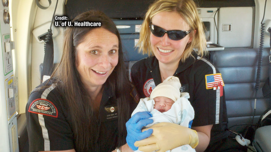 Members of the AirMed high-risk obstetrical team hold the new baby boy delivered in flight.
