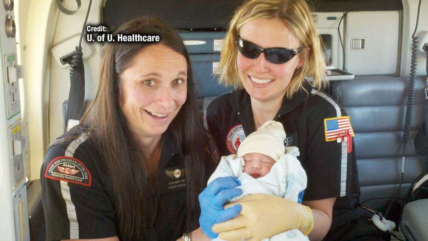 Members of the AirMed high-risk obstetrical team hold the new baby boy delivered in flight.