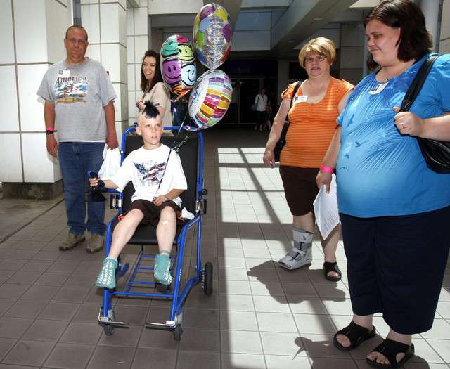 Carson Jones, center, who nearly drowned in the Grantsville Reservoir on Saturday night, leaves Primary Children's Medical Center with his parents Jacob Jones, left, and Hailey Jones, right, and grandmother Kathie Alexander, center right.(Scott G. Winterton, Deseret News)