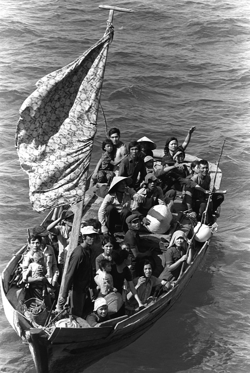 Thirty-five Vietnamese refugees wait to be taken aboard the the USS Blue Ridge. They were 350 miles northeast of Cam Ranh Bay, Vietnam, after spending eight days at sea. (Credit: Public domain)