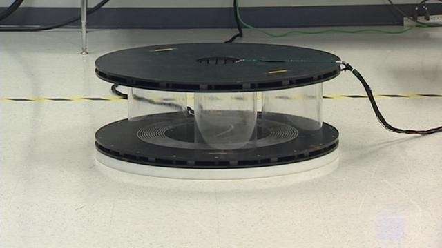 USU researchers set an electrical coil or pad on the floor. Plastic cylinders on top of the pad are used as spacers to create the 10-inch gap. A receiving pad goes on top of the cylinders. Electric current in the lower pad creates a magnetic field that bridges the gap.