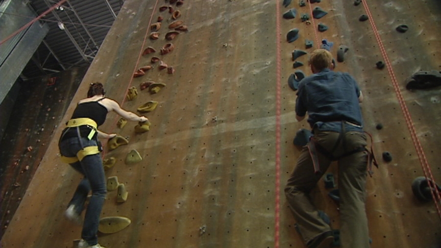 Instructor Michelle Legg, left, show's KSL's Jed Boal, right, the best way to get up the rock wall at Monument Climbing