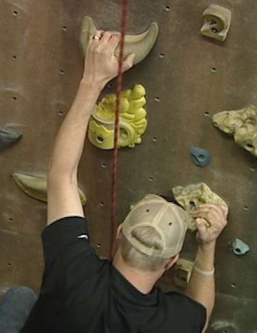 AJ from 97.1 ZHT works to get up the rock wall at Monument Climbing