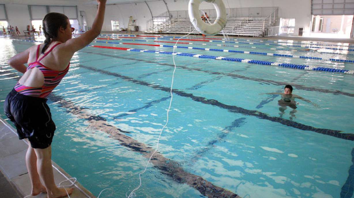 Hillary Hermonson, left, tosses a ring buoy to teammate Joel Benedicto as they compete in the annual Lifeguard Games Saturday, July 16, 2011, at the Kearns Oquirrh Park Fitness Center. Experts warn that the nationwide lifeguard shortage could prove deadly during Memorial Day weekend.