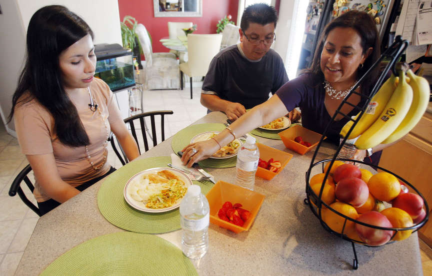Laura Leon, her father Gustovo I Leon and Olga Rubiano sit down to enjoy a meal Thursday, July 28, 2011 at home. Olga and Laura teach classes in the Hispanic community for the Utah Health Department. (Photo: Scott G. Winterton, Deseret News)