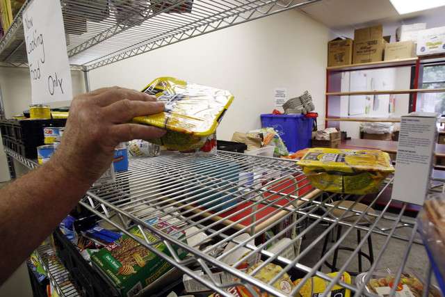 A worker takes an item off the mostly empty shelves of Hildegarde's Pantry at St. Mark's Cathedral, Friday, July 29, 2011.
(Photo: Ravell Call, Deseret News)