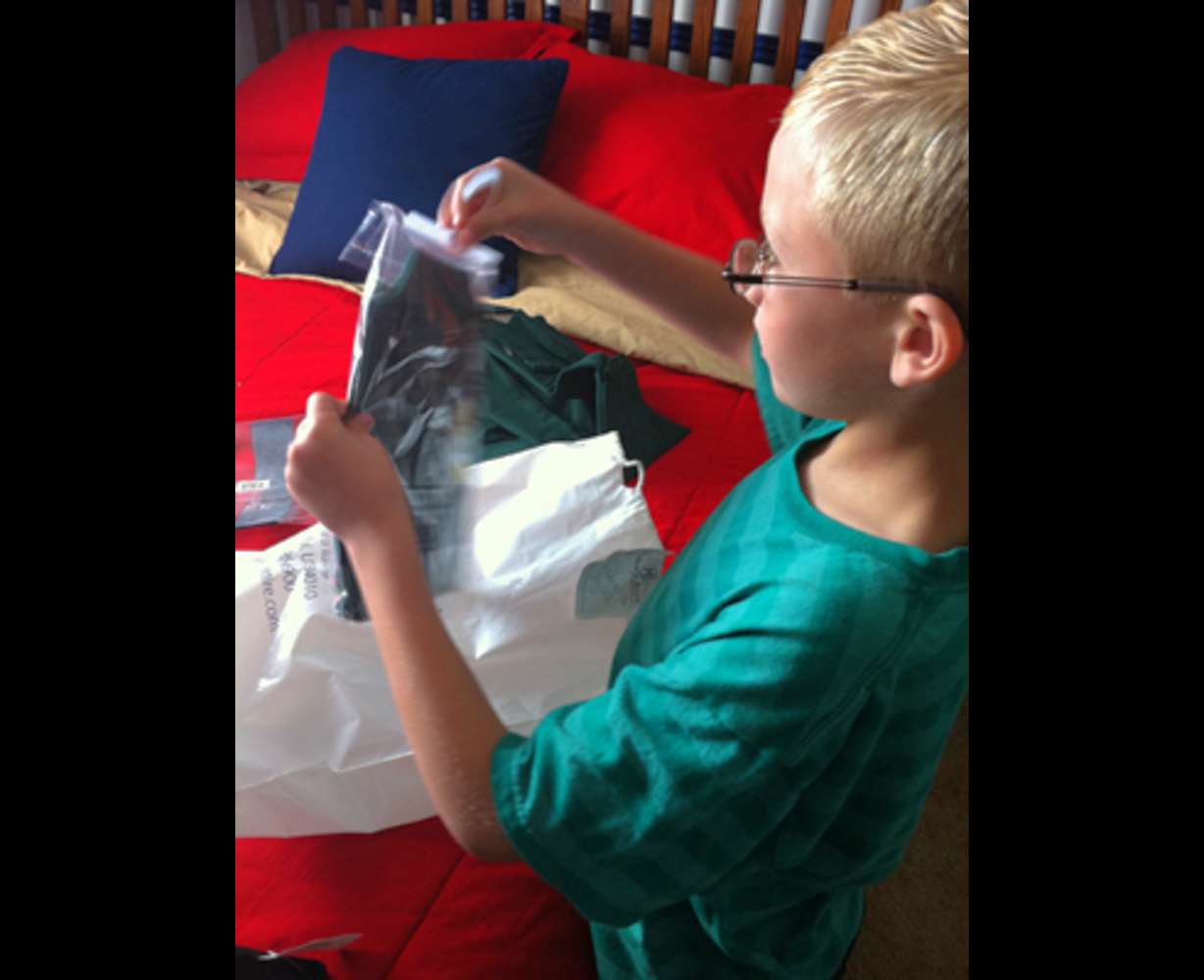 Jensen Coombs gets his clothes ready prior to attending a charter school.