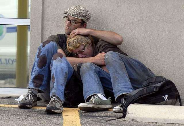 Two men console one another other after a woman they were traveling with fell under a Burlington Northern Santa Fe train in Longmont, Colo., on Monday, Sept. 5, 2011. (AP Photo/Longmont Times-Call, Richard M. Hackett)