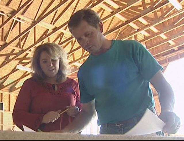Sergei Dengin and his wife, Jennifer, look over plans they've created for another of their Fancy Built playhouses.
