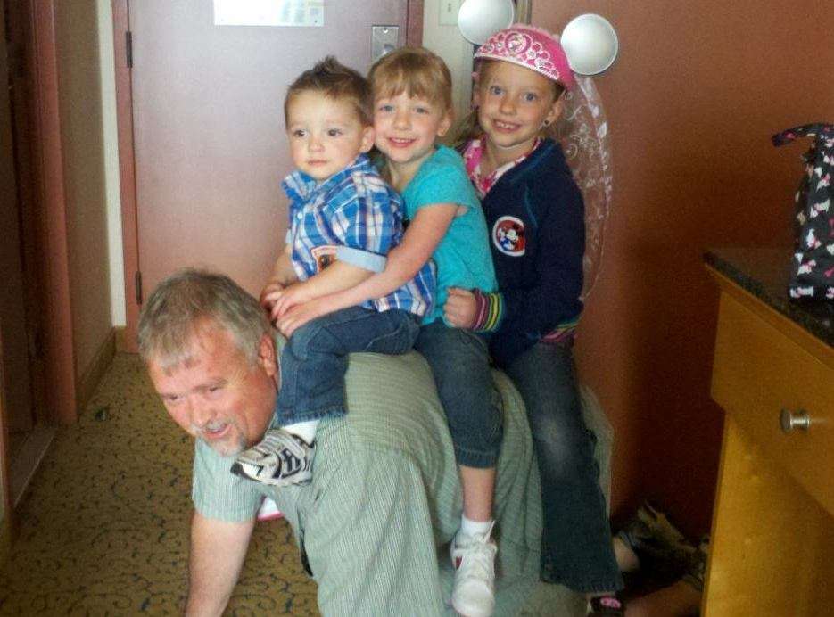 "Papa Dave" has forged a loving, lasting bond with his grandchildren,
2-year-old Collin, 4-year-old Savannah, and 7-year-old Jackie, shown
here while on a family trip to Disneyland.