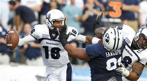 USU quarterback Chuckie Keeton fight's off BYU's Hebron Fangupo. (AP Photo/George Frey)