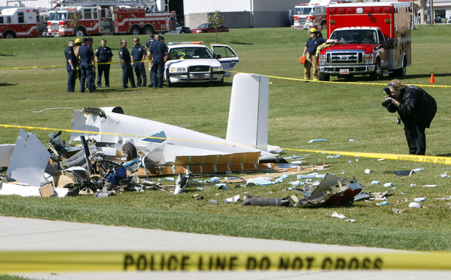 A crime scene photographer documents the wreckage of a small plane that crashed Tuesday, Oct. 4, 2011. The plane carrying two adult males crashed just moments after takeoff from South Valley Regional Airport on a soccer field at the West Jordan Soccer Complex. (Photo: Scott G Winterton, Deseret News)