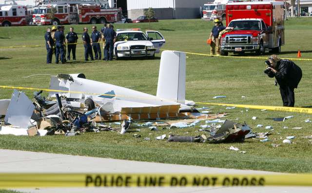 A crime scene photographer documents the wreckage of a small plane that crashed Tuesday, Oct. 4, 2011. The plane carrying two adult males crashed just moments after takeoff from South Valley Regional Airport on a soccer field at the West Jordan Soccer Complex. (Photo: Scott G Winterton, Deseret News)