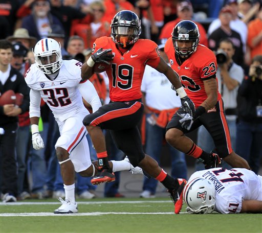 Oregon State running back Jovan Stevenson (19) leaves Arizona defenders Lyle Brown, left, and Paul Vassallo behind as he heads downfield. (AP Photo/Don Ryan)