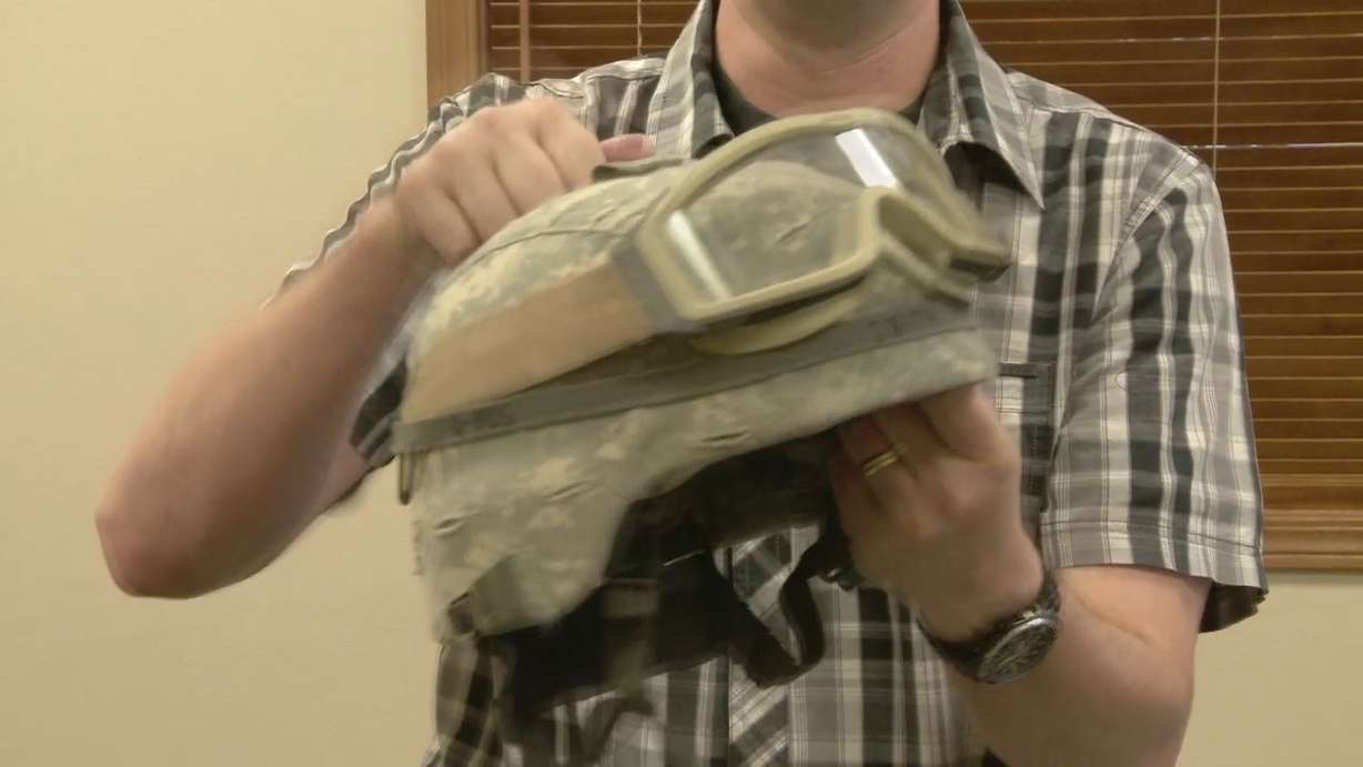 "(It's) bullet-proof, hopefully," St. George
radio host Jon Smith said with a grin as he
wrapped on the Kevlar helmet he'll wear all
week.