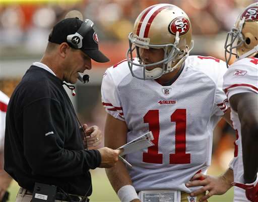 San Francisco 49ers head coach Jim Harbaugh,
left, talks with quarterback Alex Smith. (AP
Photo/Ed Reinke)
