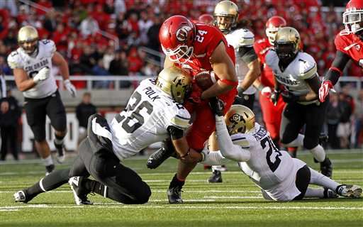 Utah running back Tauni Vakapuna (24) is
tackled by Colorado defensive backs Ray Polk
(26) and Greg Henderson (20. Colorado won 17-
14. (AP Photo/Jim Urquhart)