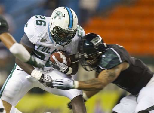 Tulane running back Orleans Darkwa (26) is hit
by Hawaii linebacker Aaron Brown. (AP
Photo/Eugene Tanner)